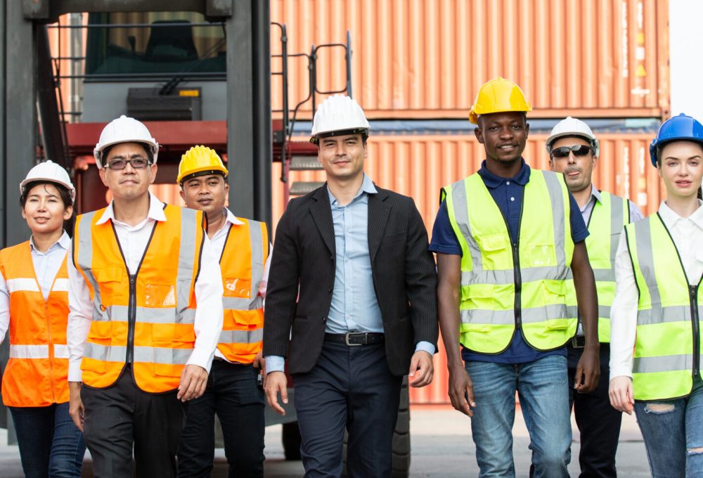 Corporate logistic team walking together at container warehouse. group of staff employee following foreman leader. teamwork and business vision concept