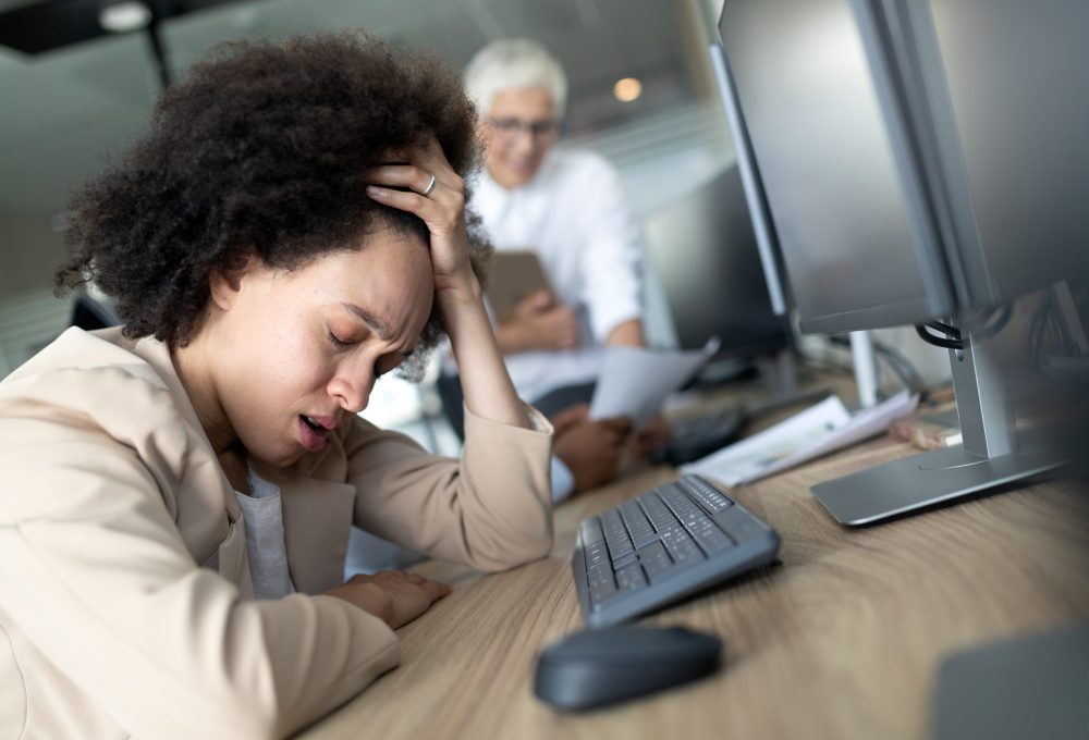 Portrait of an exhausted young business woman sleeping at work