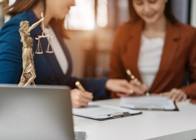 statue of justice with scales and auction hammer, the team meeting at the law firm behind the concept of in office law.